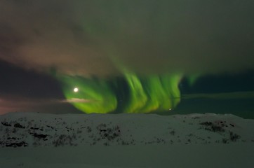 snow covered the hills and in the sky stars, clouds and northern lights.
