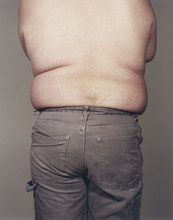 View From Behind Of Overweight Man Wearing No Shirt