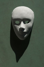 White Human Face Mask With A Shadow On A Green Backg