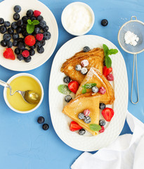 Wall Mural - Pancakes with fresh berries and honey.