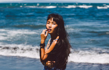 Asian Woman Standing By The Deep Blue Ocean View