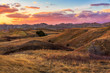 The sun sets over the golden fields of Badlands National Park, South Dakota