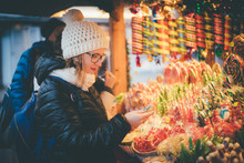 Happy Beautiful Woman Selecting Traditional Holiday Candies On Christmas Market