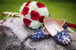 Sikh wedding sword, grooms Indian shoes and bridal bouquet on a rock.