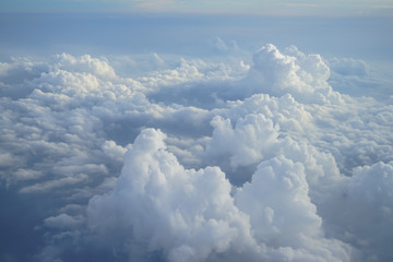 view of beautiful heaven cloudscape with shades of blue sky background from flying plane window