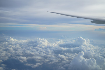 Wall Mural - view of beautiful cloudscape with shades of blue sky background from flying plane window with airpla