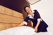 Positive delighted chambermaid working in luxury room