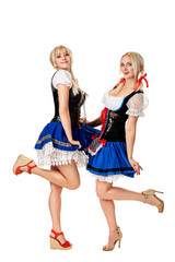 Wall Mural - A full length portrait of two beautiful women in a traditional costume isolated on white. Oktoberfest