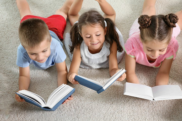 Cute little children reading books indoors