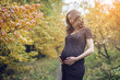 © Artem - Portrait of pregnant woman belly in colorful autumn forest in September. Concept of pregnancy and the seasons