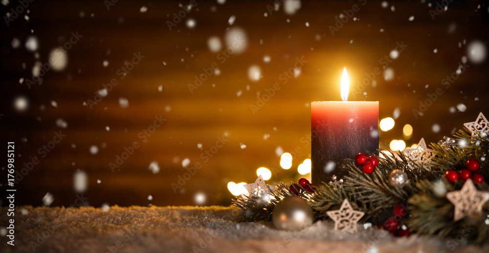 Kerze mit festlicher Dekoration und Holz Hintergrund bei fallendem Schnee, ideal für Advent und Weihnachten Stock Photo