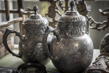 Two silver teapots on display