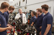 © Monkey Business - Apprentices studying car engines with a mechanic, close up
