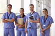 © Monkey Business - Group portrait of healthcare workers in hospital corridor