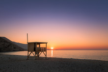 Sun Setting Behind Lifeguard Tower On Ostriconi Beach In Corsica