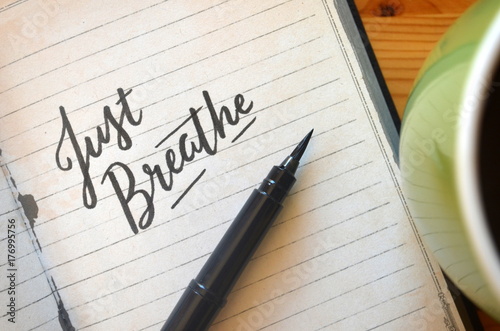 Fotografie, Obraz JUST BREATHE brush calligraphy in notebook with cup of coffee on desk