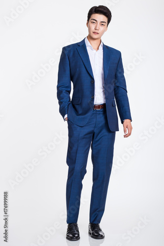 Fotografie, Obraz Studio portrait of a confident businessman posing against a gray background