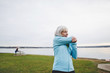 © Rob and Julia Campbell/Stocksy - Healthy, active senior woman stretching outside near ocean