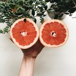 © katieandjoe/Stocksy - Two grapefruit halves on a white table