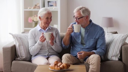 Wall Mural - happy senior couple drinking coffee at home