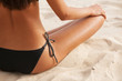 © Sean Locke Photography/Stocksy - Tropical: Tanned Woman In Bikini Sitting On Beach