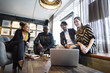 © jacoblund/Stocksy - Happy business team working in relaxed cafe setting