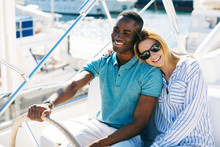 Young Multiethnic Couple Enjoying A Sunny Day On A Luxurious Yacht.