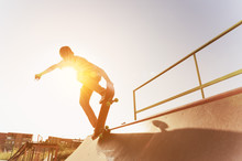 Teen Skater Hang Up Over A Ramp On A Skateboard In A Skate Park