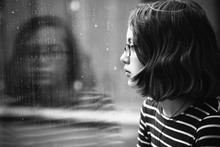 Girl Looking Out Of Window At The Rain