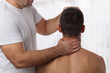 © dream@do - Chiropractic back adjustment. Muscular Man suffering from back and neck pain.