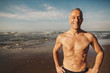 © Rob and Julia Campbell/Stocksy - Active senior man - in great shape - smiling shirtless on beach in morning sunshine