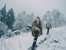 People Climbing Hill In Snow