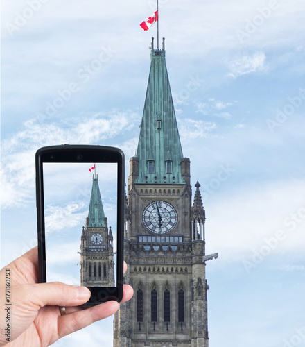 Plakat Ręka trzyma smartphone przechwytywanie Wieży Pokoju budynków Parlamentu. Ottawa, Ontario. Kanada.