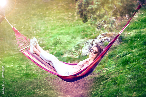 Plakat kobieta relaks w hamaku na świeżym powietrzu w parku.