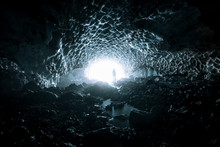 Mysterious Ice Cave In Germany With Young Adult Male Standing In The Light