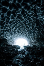 Person Standing Inside A Glacial Ice Cave