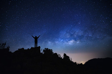 Wall Mural - landscape with milky way galaxy, starry night sky with stars and silhouette of a standing sporty man