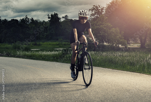 Plakat Azjatycka zdrowa cyklista dziewczyna jest ubranym hełm Kolarstwo i ćwiczenie na bicyklu w śladzie, otwartej drodze, krzyż proces i miękki flary filtr pracujemy out i sporta pojęcie