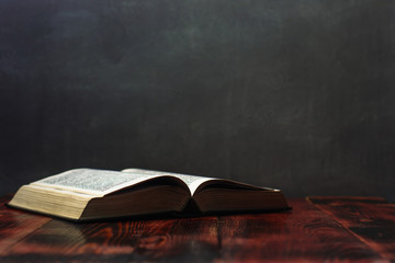 Bible and candle on a red wooden table. Beautiful background.Religion concept