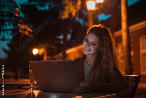 Zdjęcie XXL Piękna dziewczyna pracuje przy nocą na laptopie, outdoors. Obraz o wysokiej czułości.
