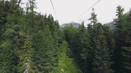 Wall Mural - Ski-lift cable car leading to Predne Solisko peak of Tatra mountains, Slovakia. Beautiful summer landscape with green pine tree forest. Sport lifestyle, holidays, travel and recreation. Full HD