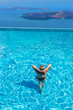 © Netfalls - Woman enjoying relaxation in pool and looking at the view