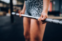 Close-Up Of Girl Doing Workout With Barbell In Gym