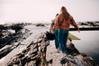 © Criene Images - Tennager girls balancing on rocks on the beach