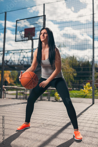 Plakat Żeński gracz koszykówki trenuje outdoors na lokalnym sądzie