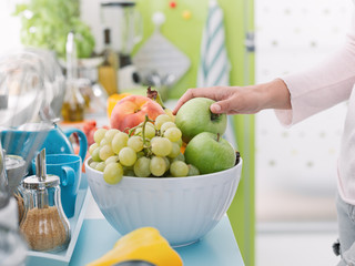 Wall Mural - Woman taking an apple from a fruit bowl