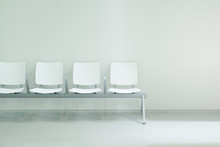 Waiting Hall Chairs Forming A Row Against A White Wall Background. Empty Copy Space For Editor's Text.