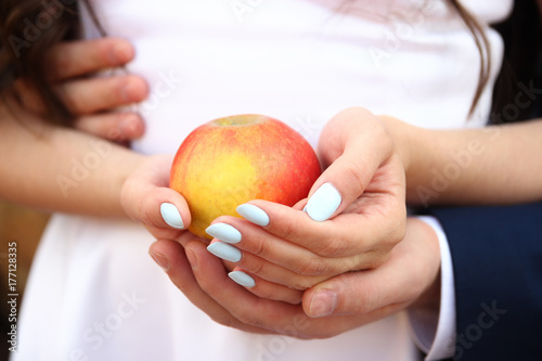 Zdjęcie XXL dziewczyna i facet trzyma czerwone jabłko