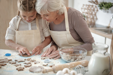 Happy granddaughter sculpting pastry from meal