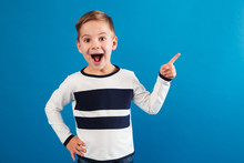 Happy Young Boy Pointing Up And Holding Arm On Hip